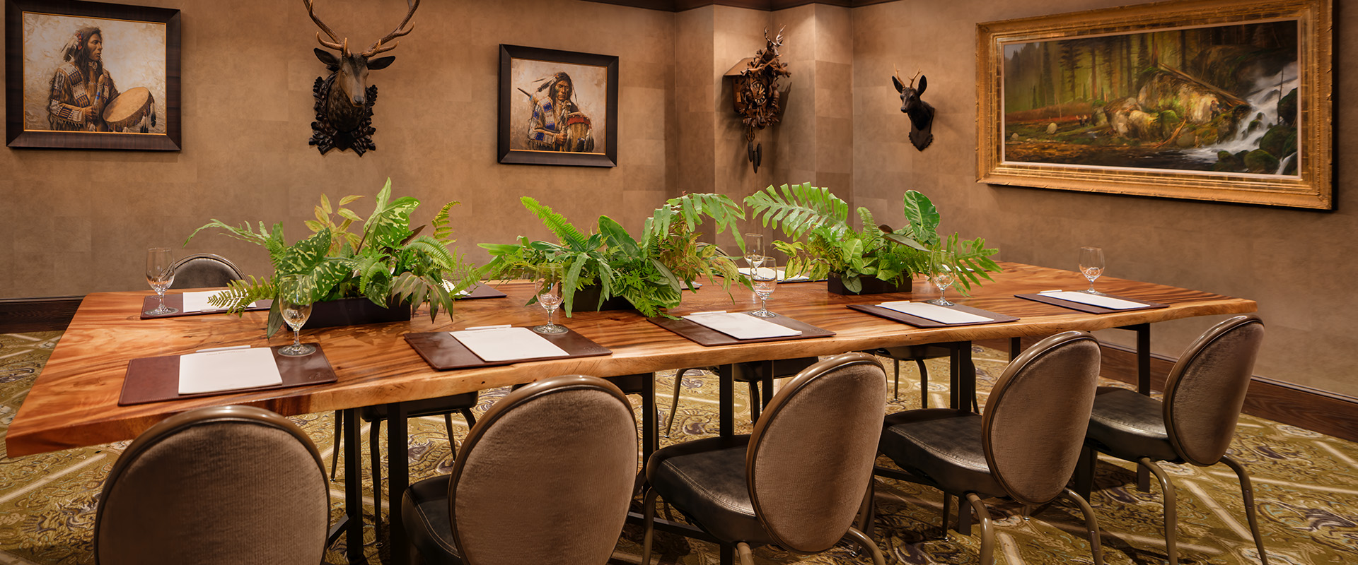 a room with a table with plants and a deer head