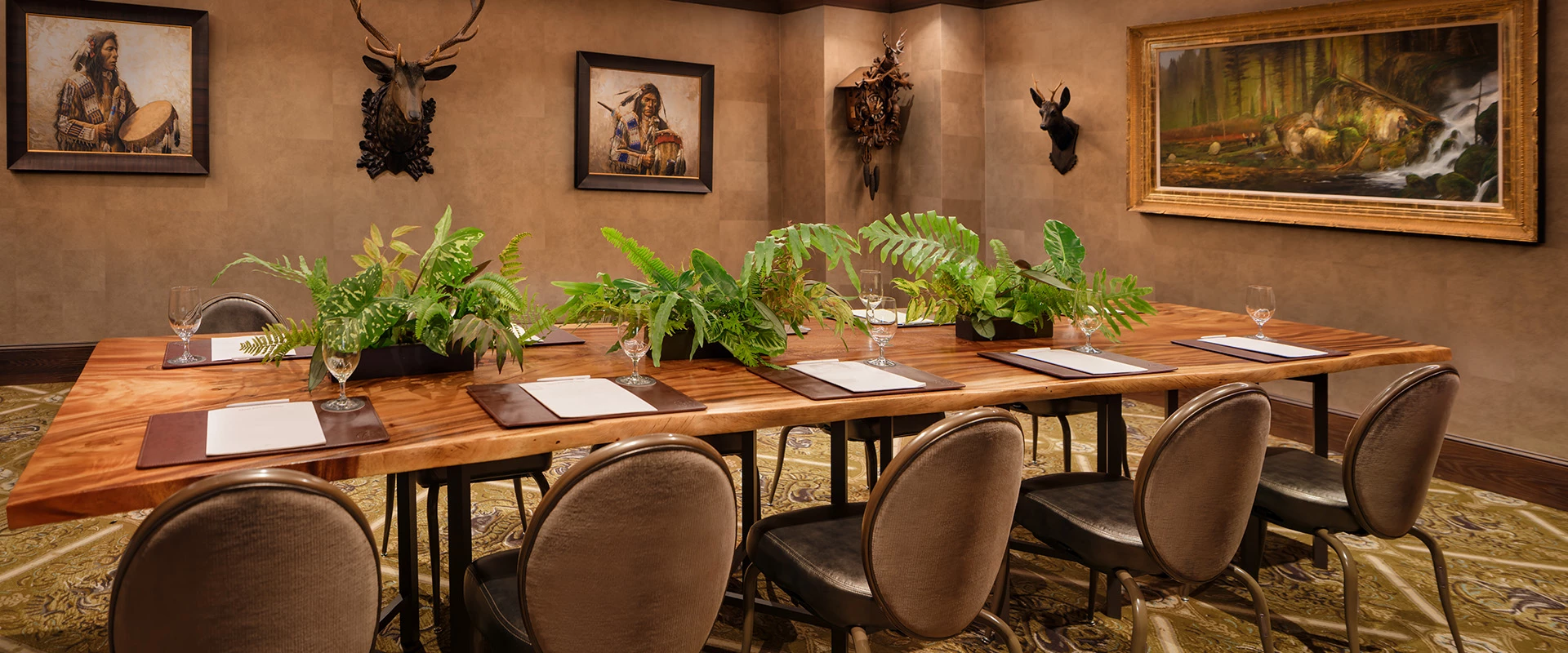 a room with a table with plants and a deer head