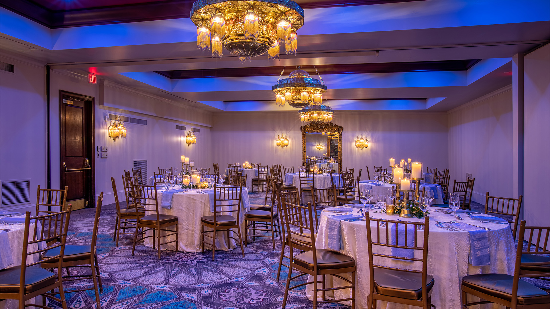 a room with tables and chairs and chandeliers