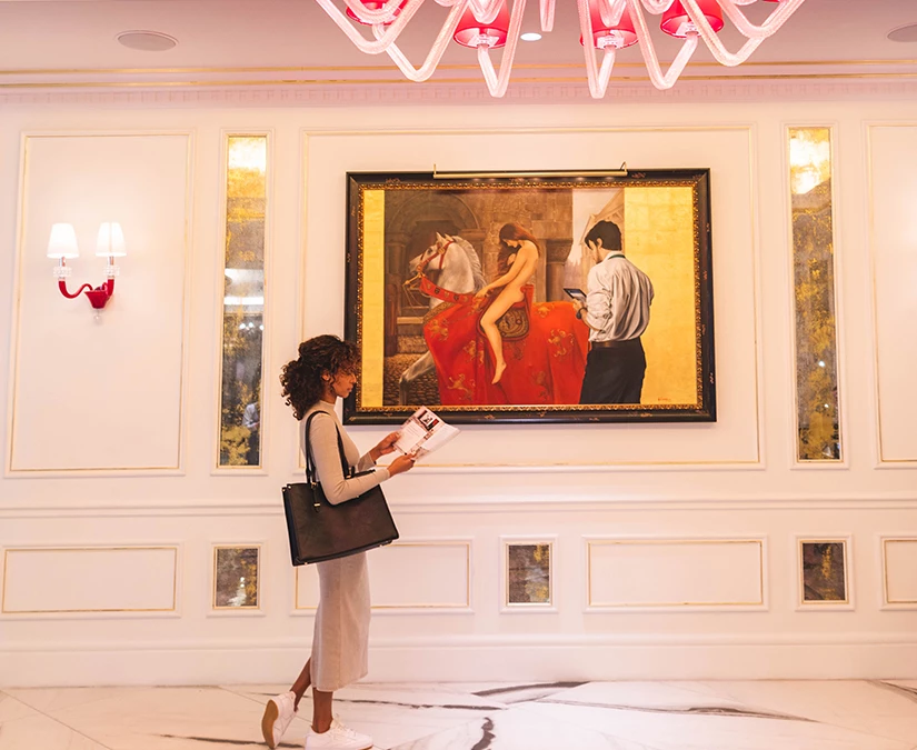 a woman walking in front of a painting