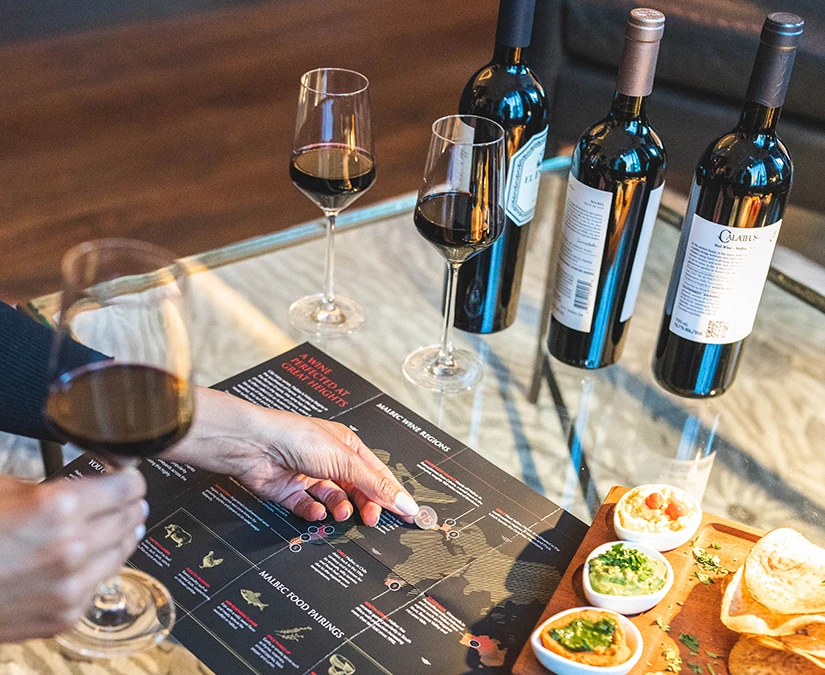 a person holding a menu with wine and wine bottles