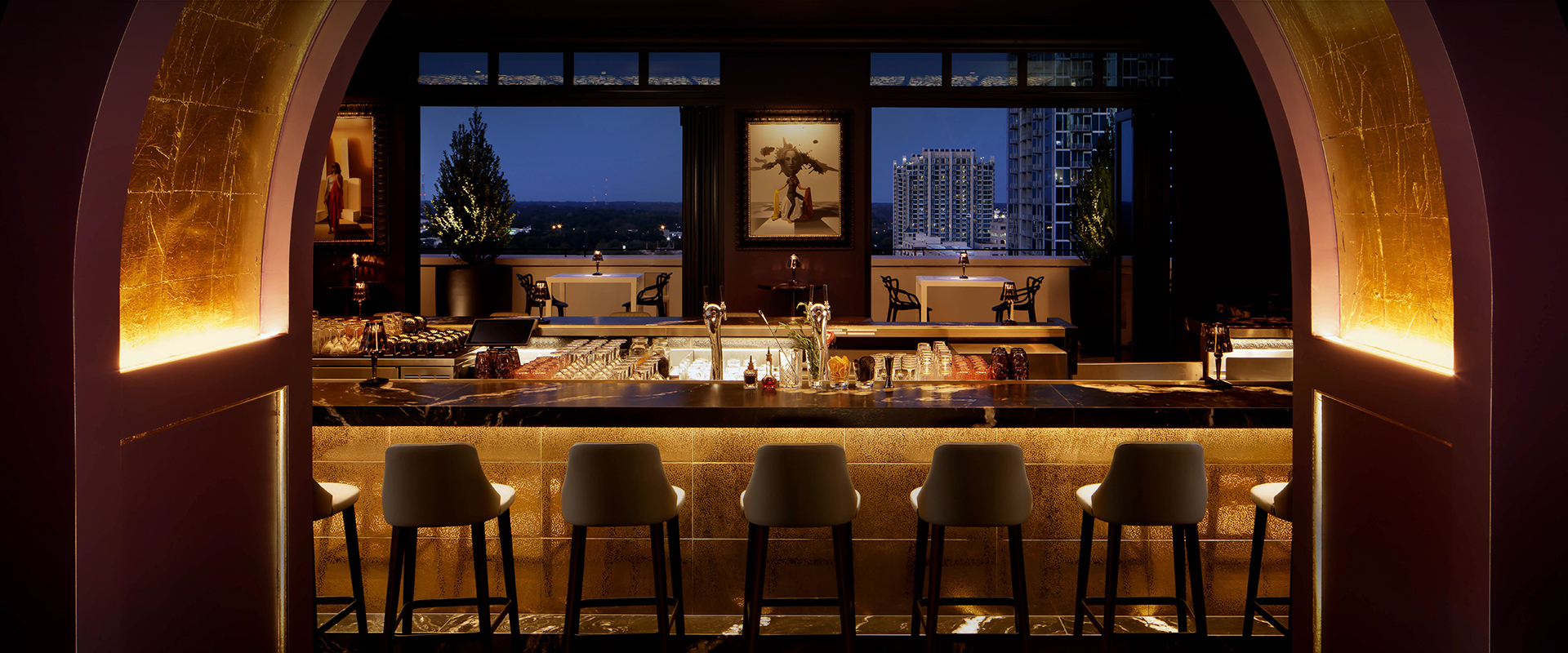 a bar with chairs and a painting on the wall