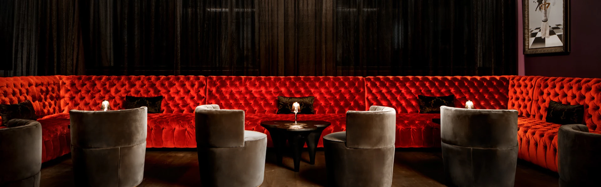 a red couch with a black pillow and a black table