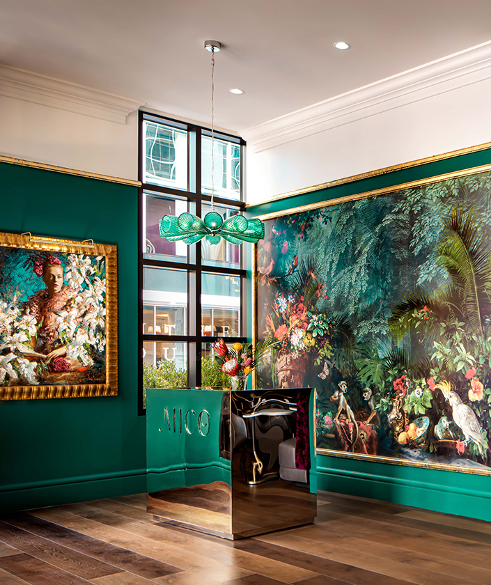 a room with a green wall and paintings