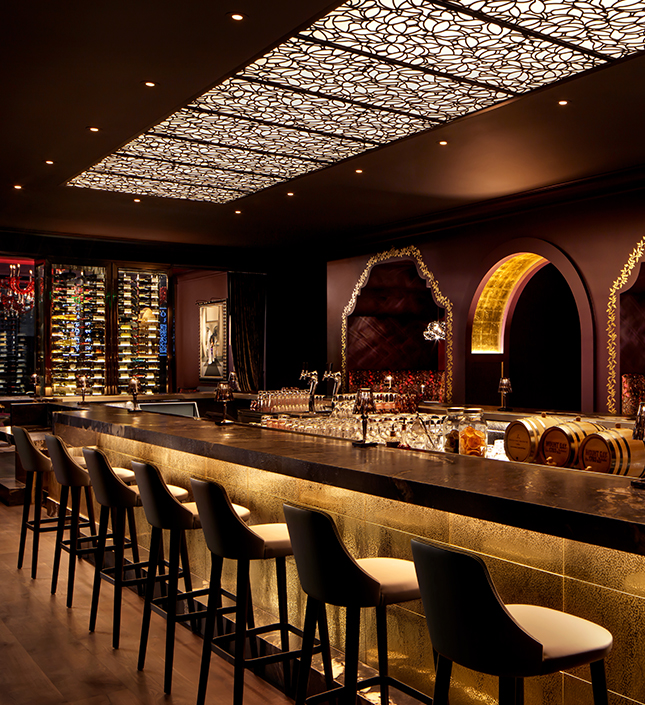 a bar with wine barrels and wine glasses