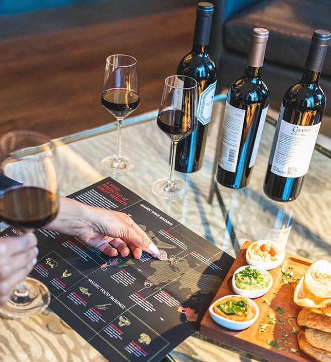 a person holding a fingerprint with wine and a menu
