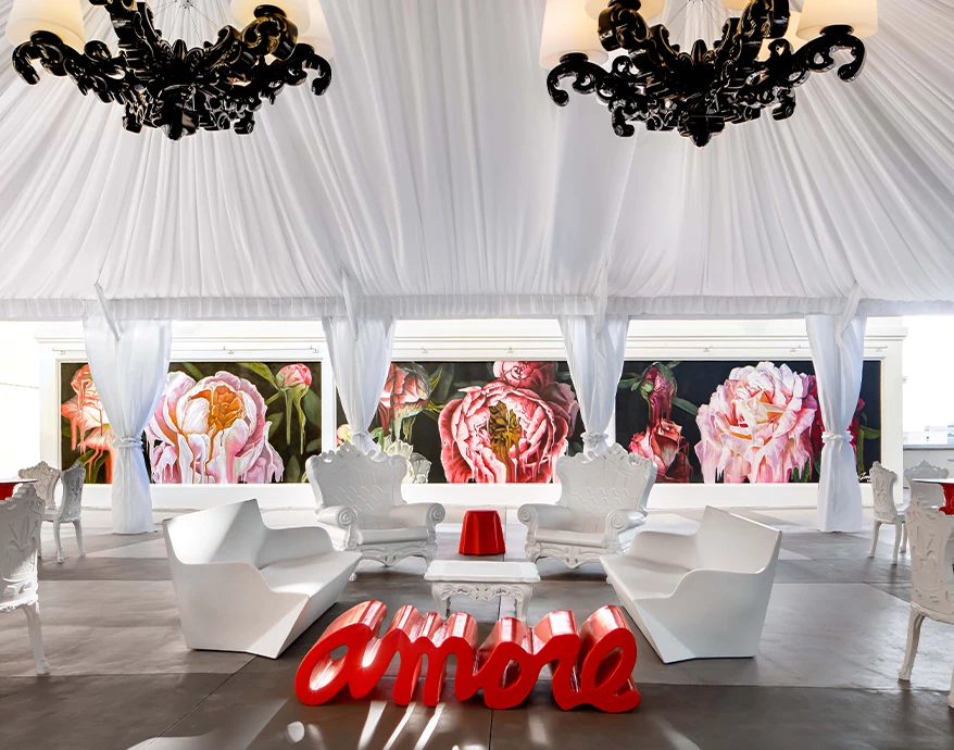 a white room with white chairs and a red table