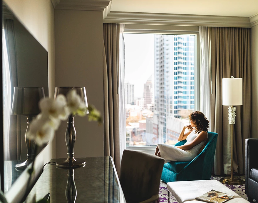 a woman sitting in a chair in a hotel room