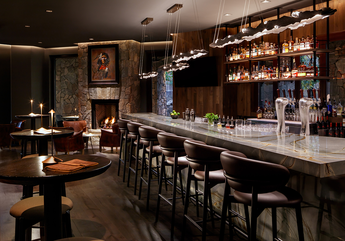 a bar with a fireplace and chairs