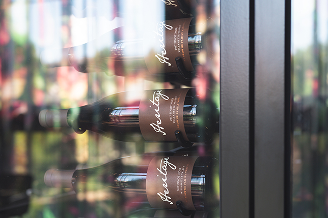 a group of wine bottles in a glass case