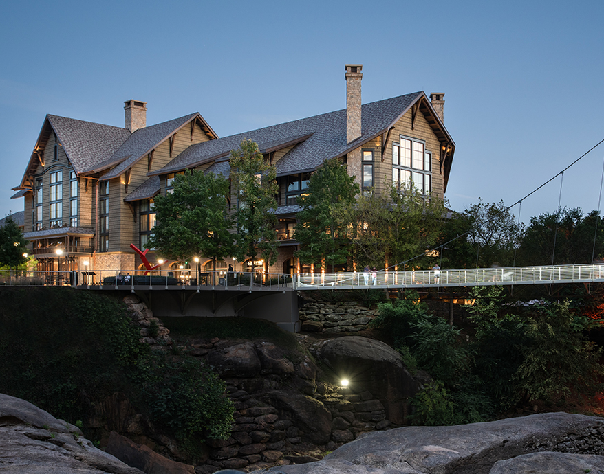 a large house with a bridge over a cliff