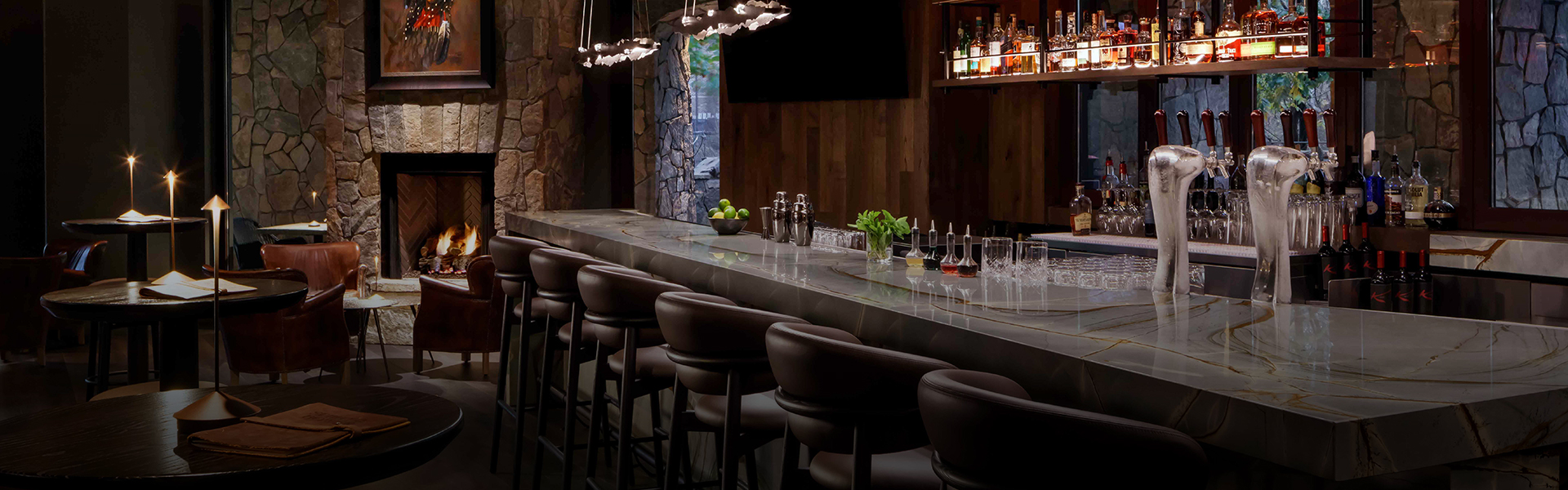 a bar with a row of chairs and bottles
