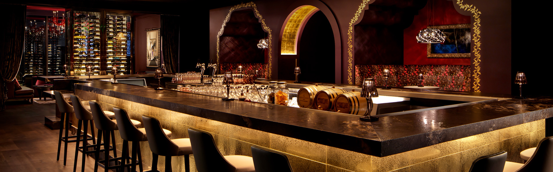 a bar with wine glasses and barrels