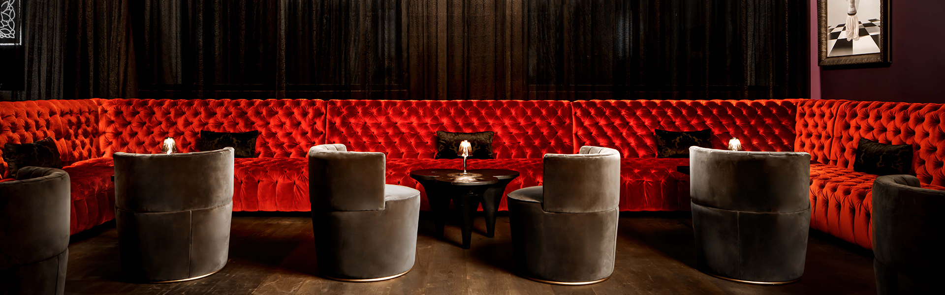 a red couch with a black table and chairs