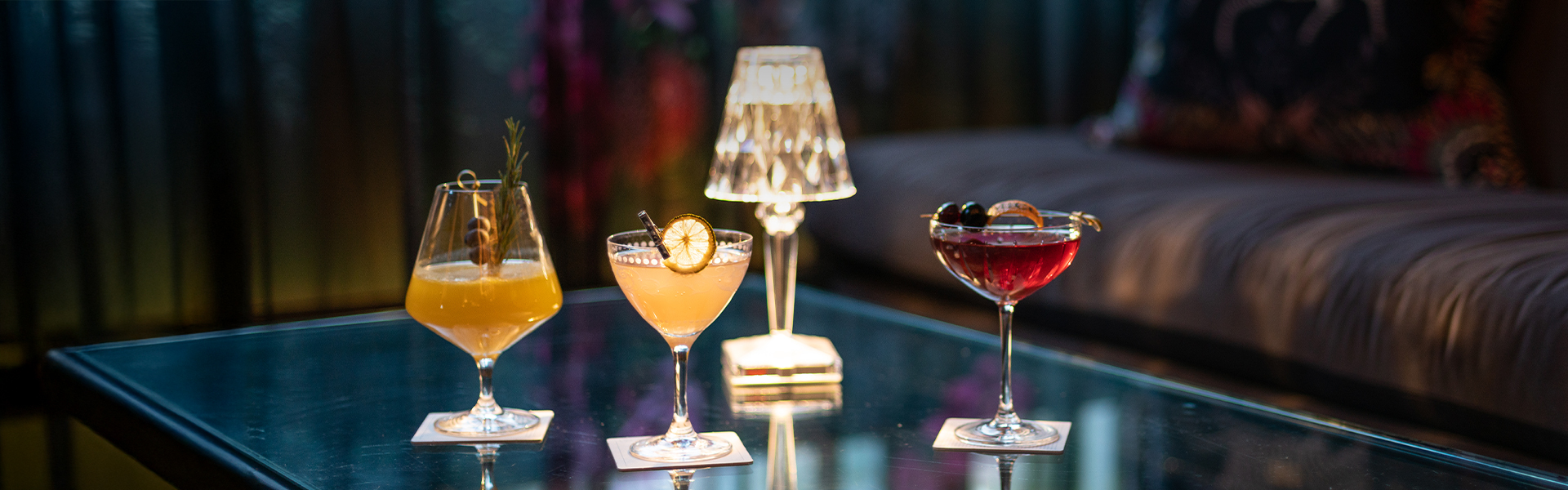 a group of glasses of different colored drinks on a table