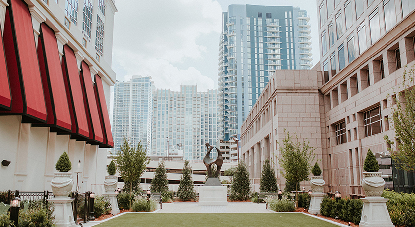 a statue in a courtyard with buildings in the background