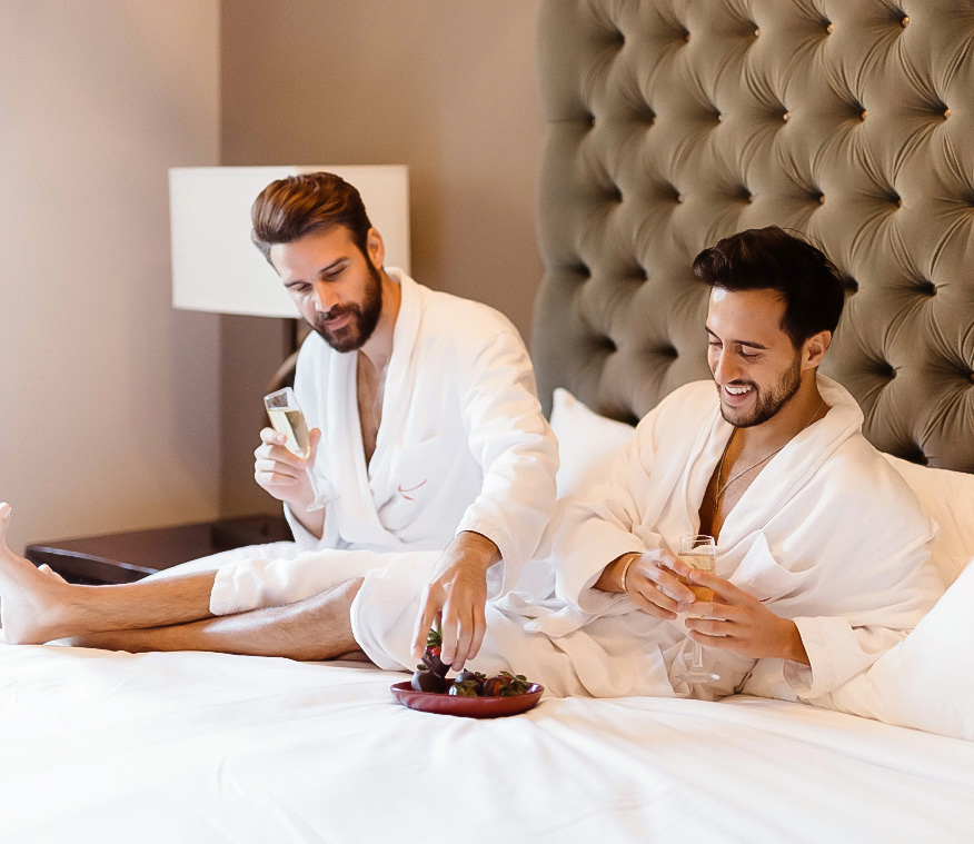 a couple of men in white robes sitting on a bed
