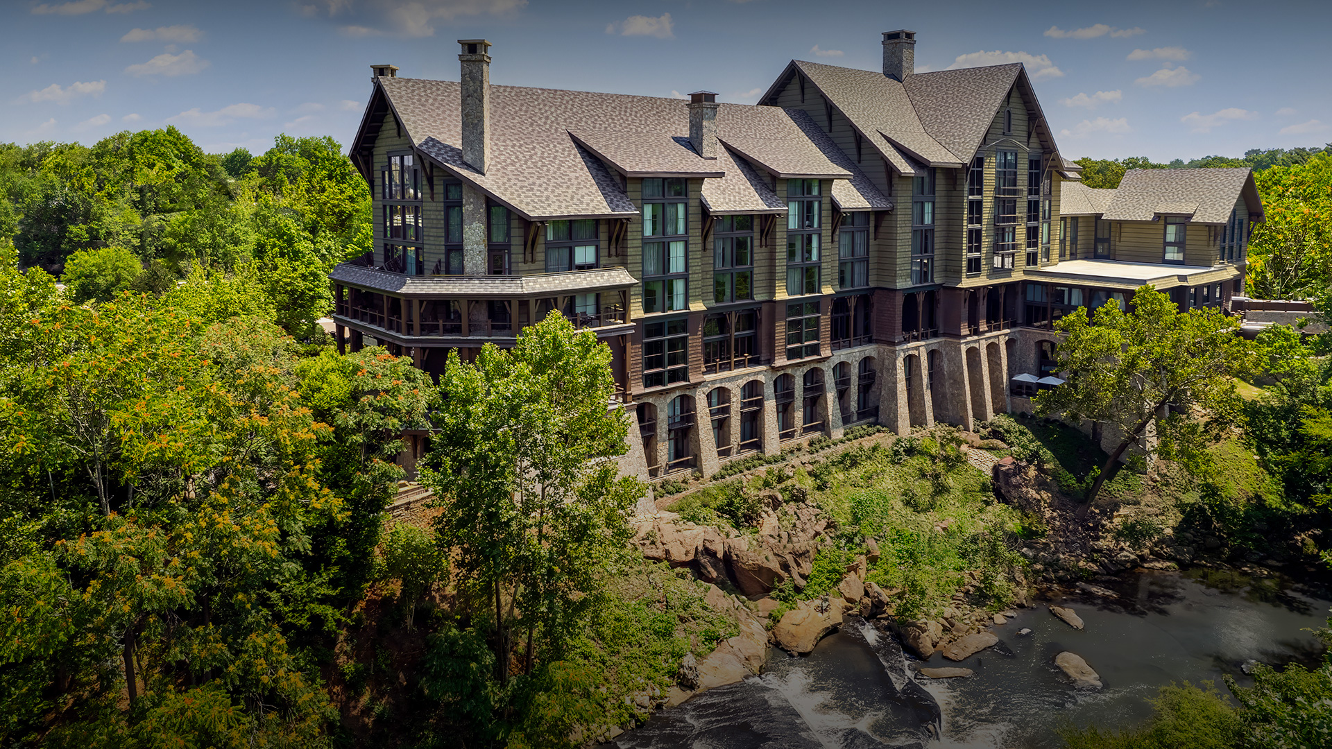 a large building with trees and a river