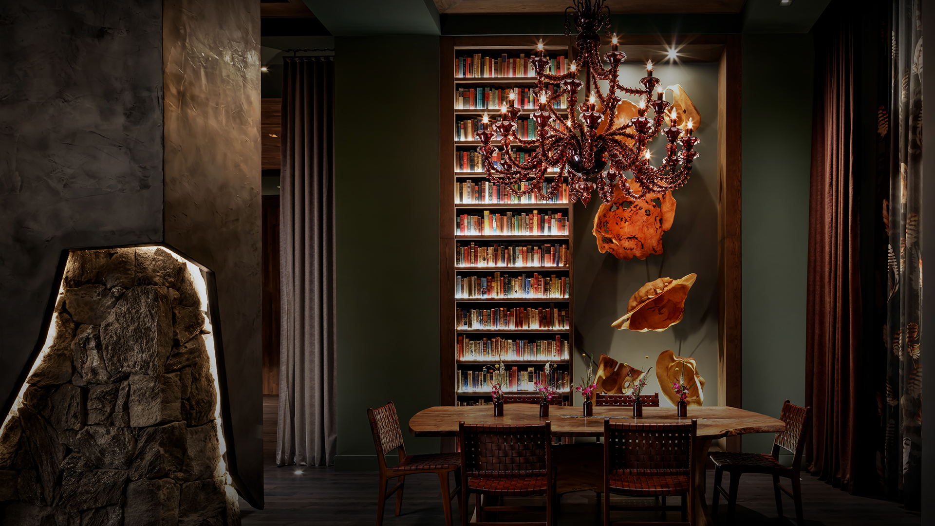 a dining room with a chandelier and bookshelves