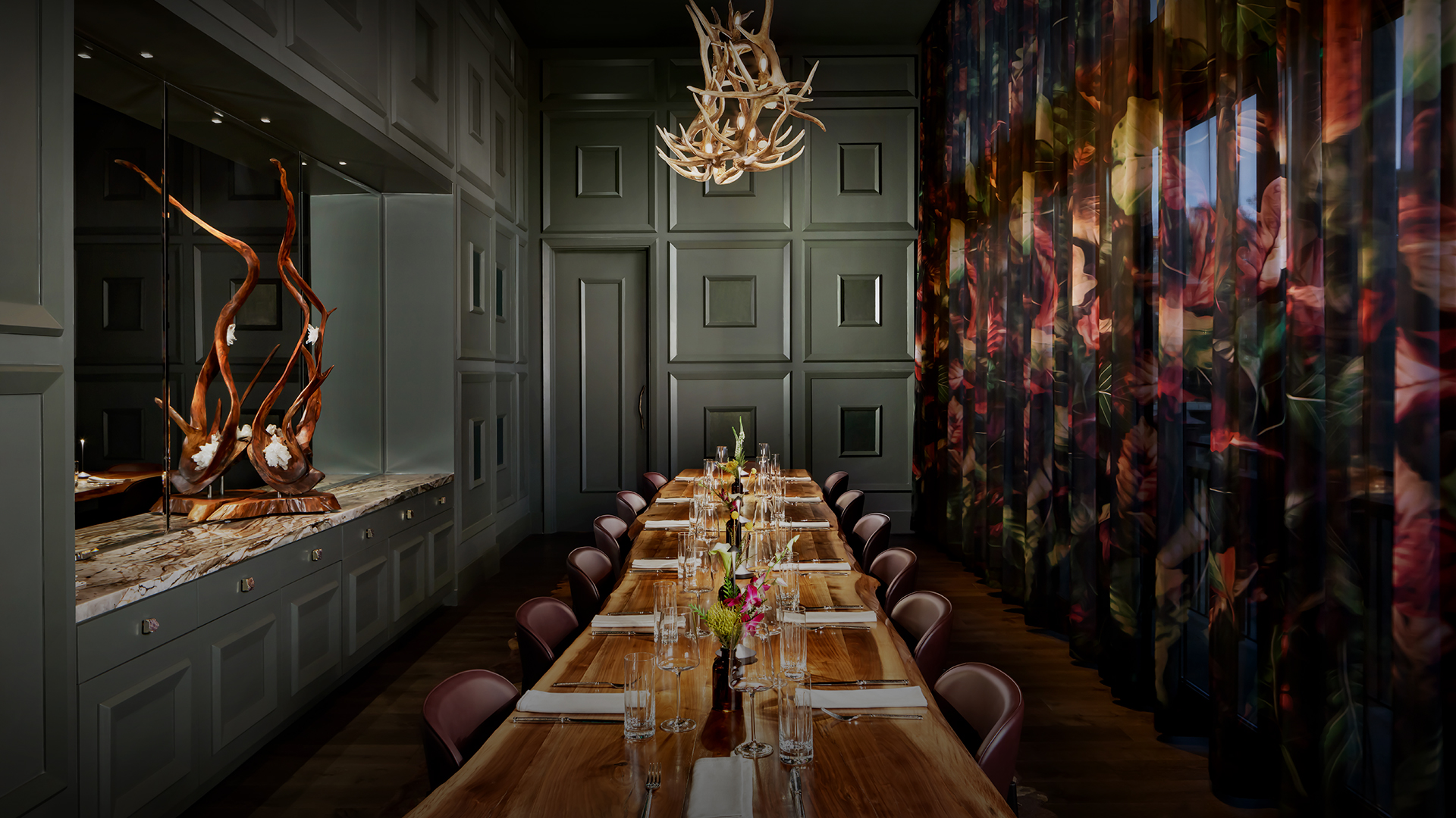 a long table with chairs and antlers