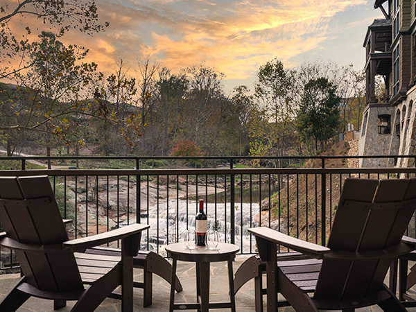 chairs on a deck with a bottle of wine on a table