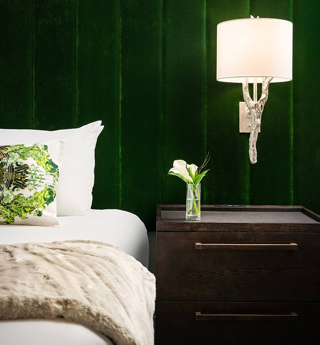 a lamp on a table next to a bed