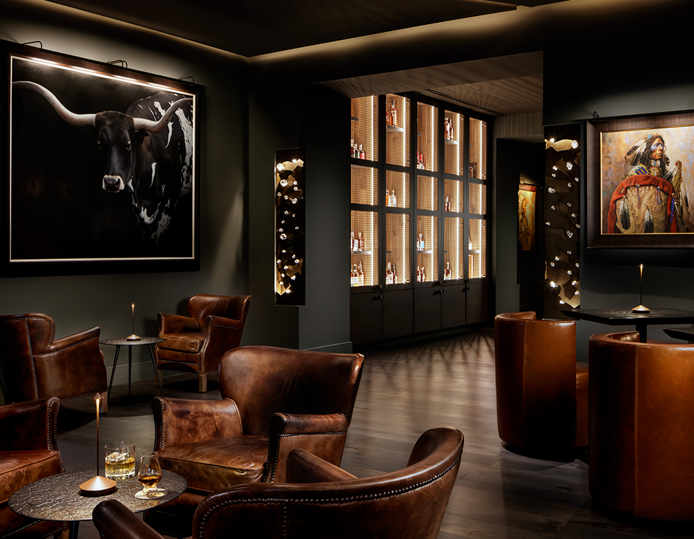 a room with leather chairs and a painting of a bull