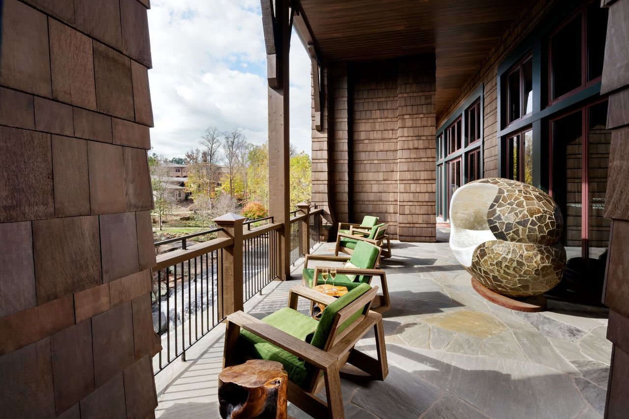 a porch with chairs and a stone sculpture