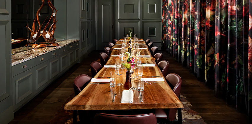 a long table with chairs and glasses