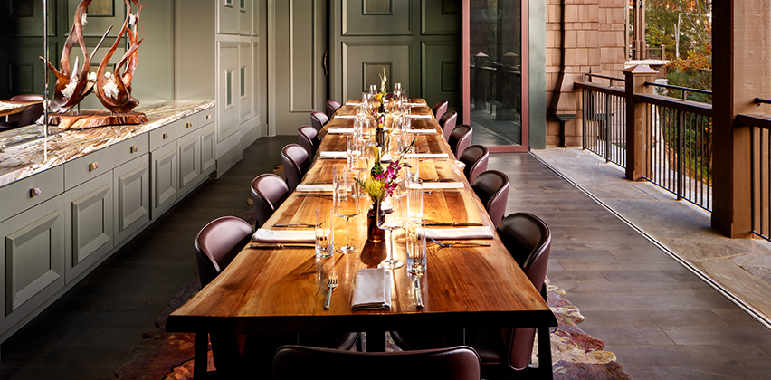 a long table with chairs and flowers