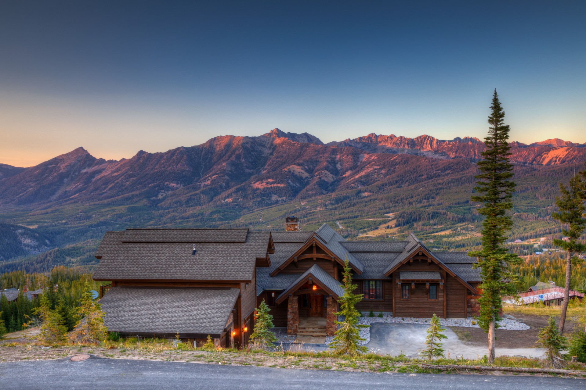 a house with trees and mountains in the background