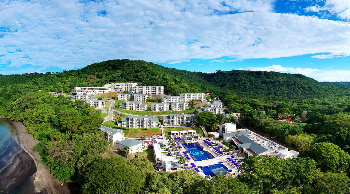 a resort with a pool and buildings in the background