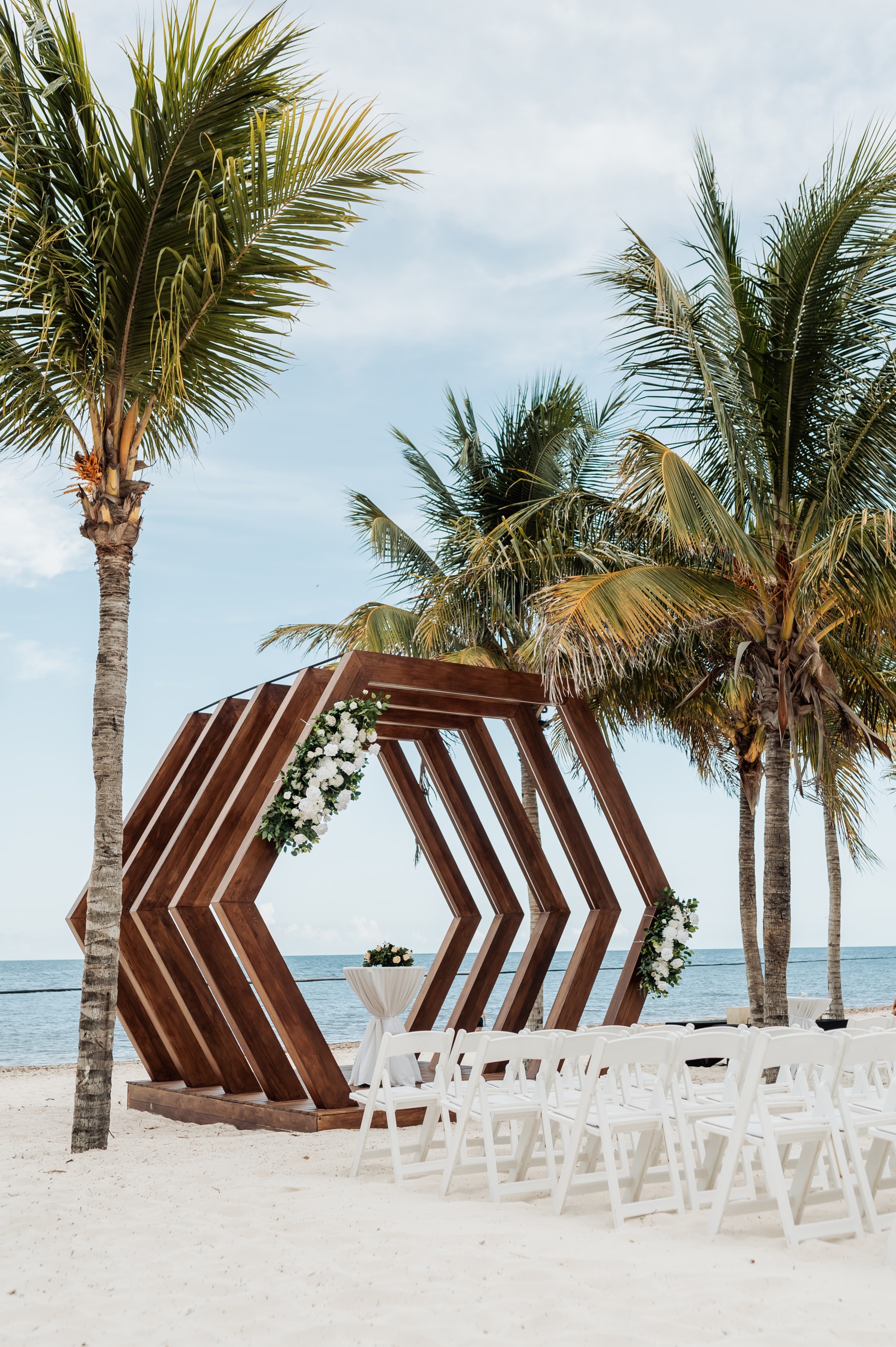 a wooden structure with chairs and tables on a beach