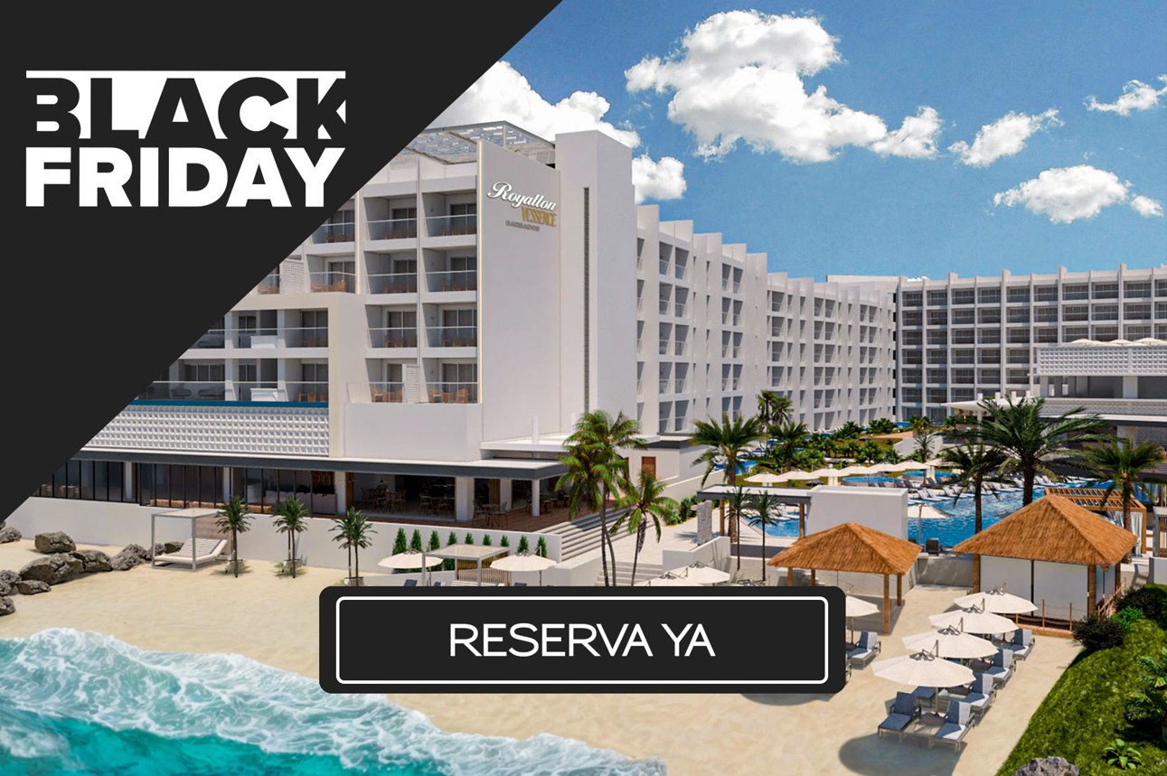 a large white building with palm trees and a beach