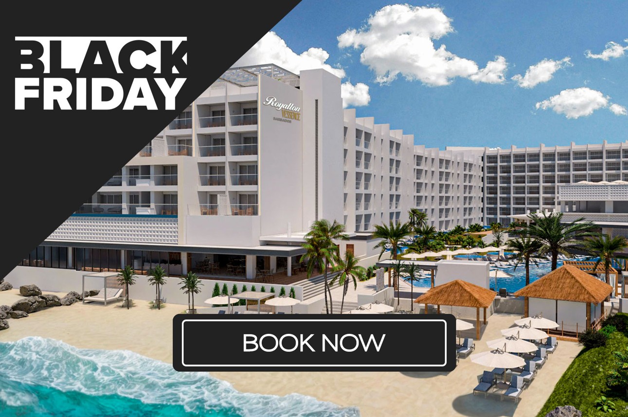 a large white building with palm trees and a beach