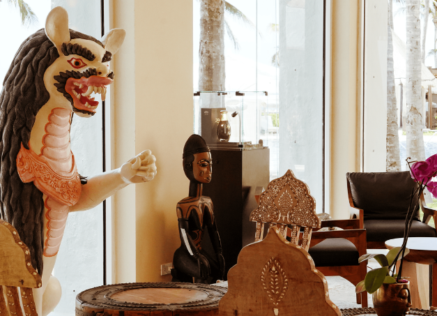a statue of a dragon in a room with a table and chairs