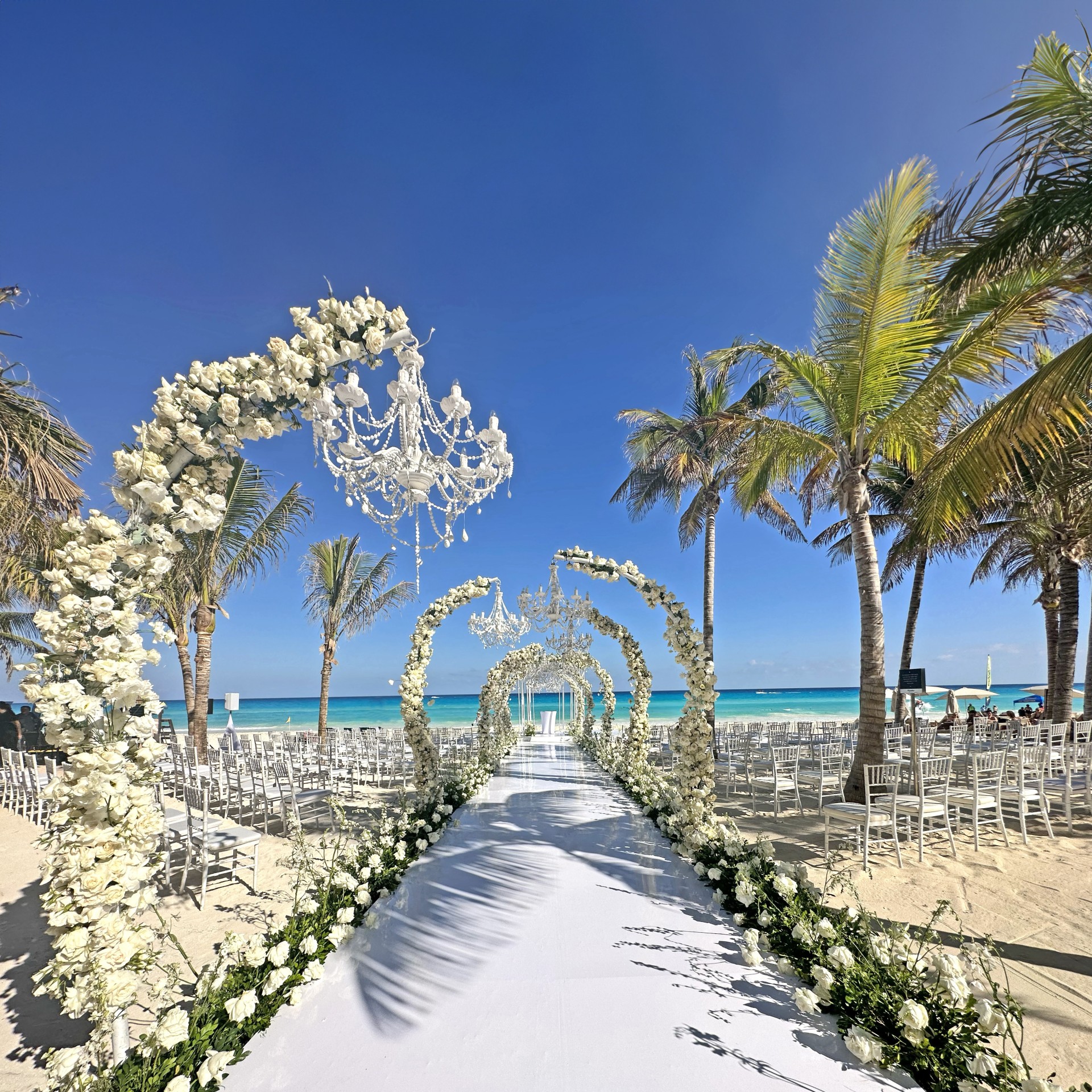 a beach wedding ceremony with palm trees and chairs