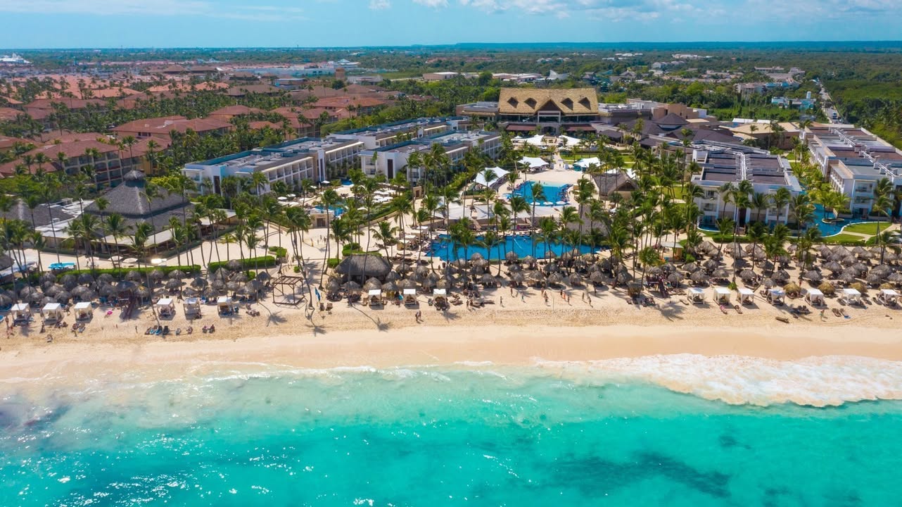 a beach with palm trees and buildings