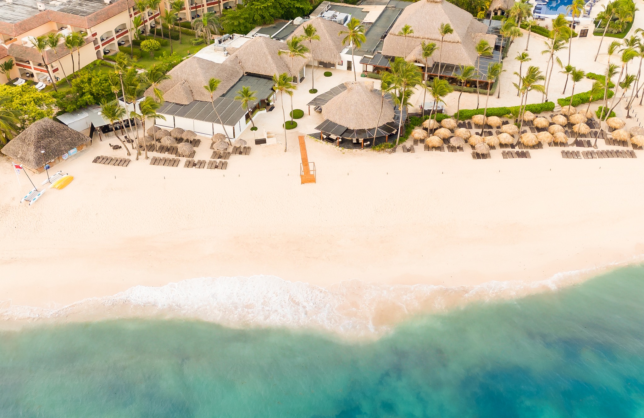 a beach with a group of buildings and a body of water