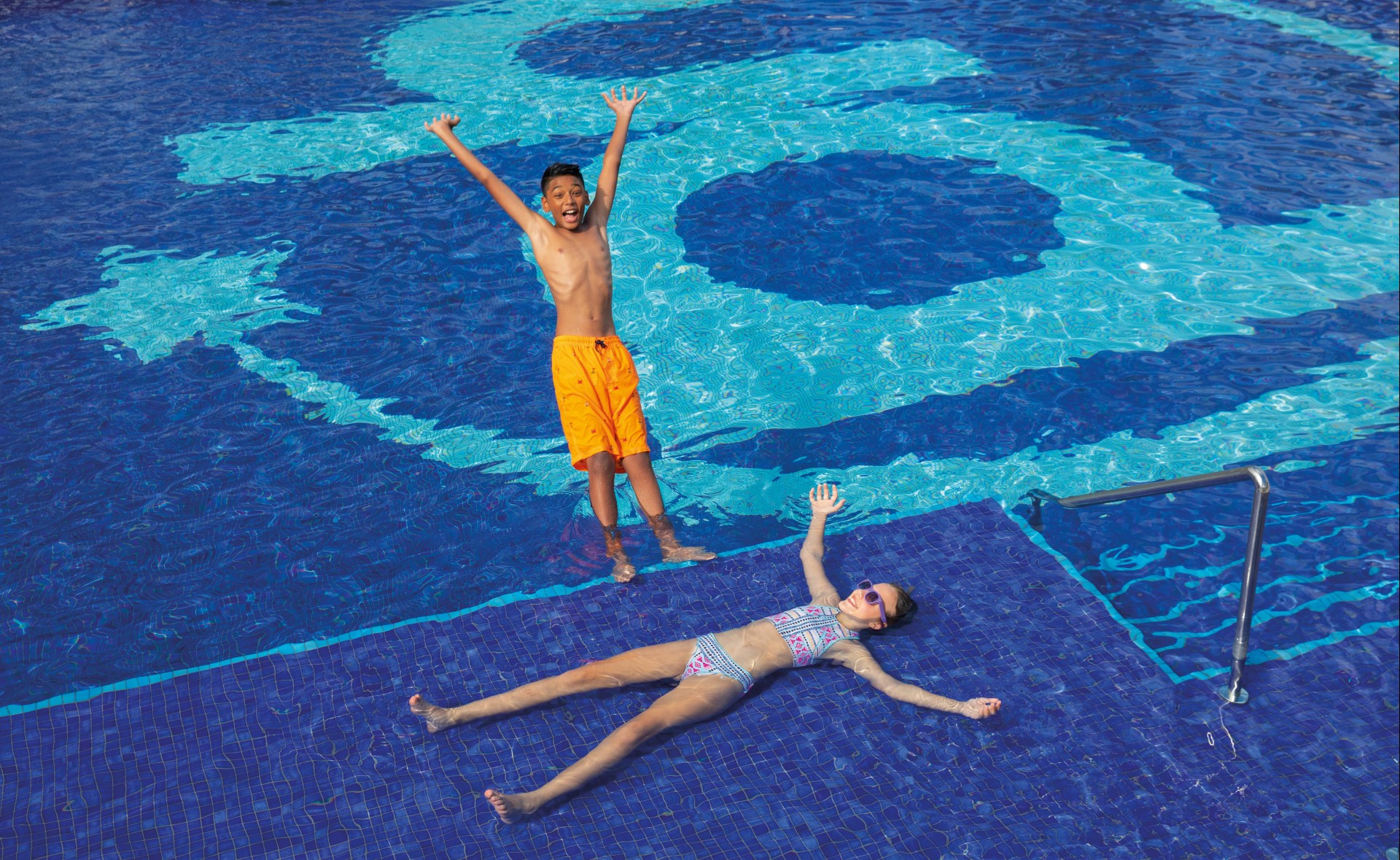 a boy and girl in a pool