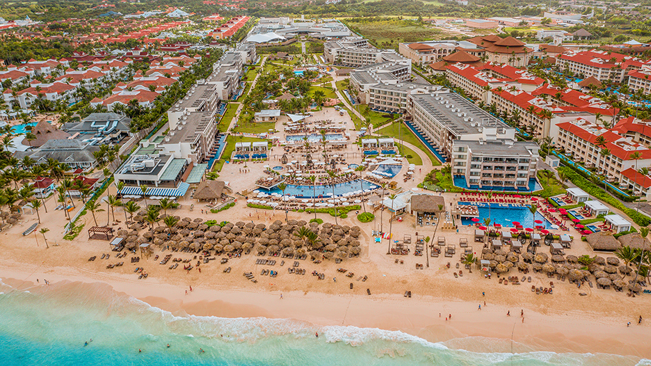 a beach with a group of buildings and a pool