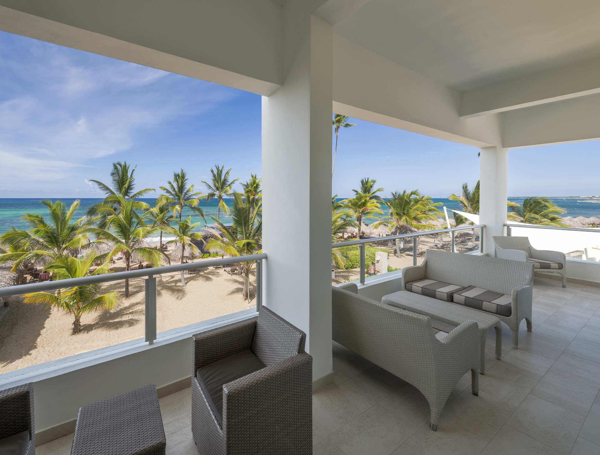 a room with a view of the ocean and palm trees