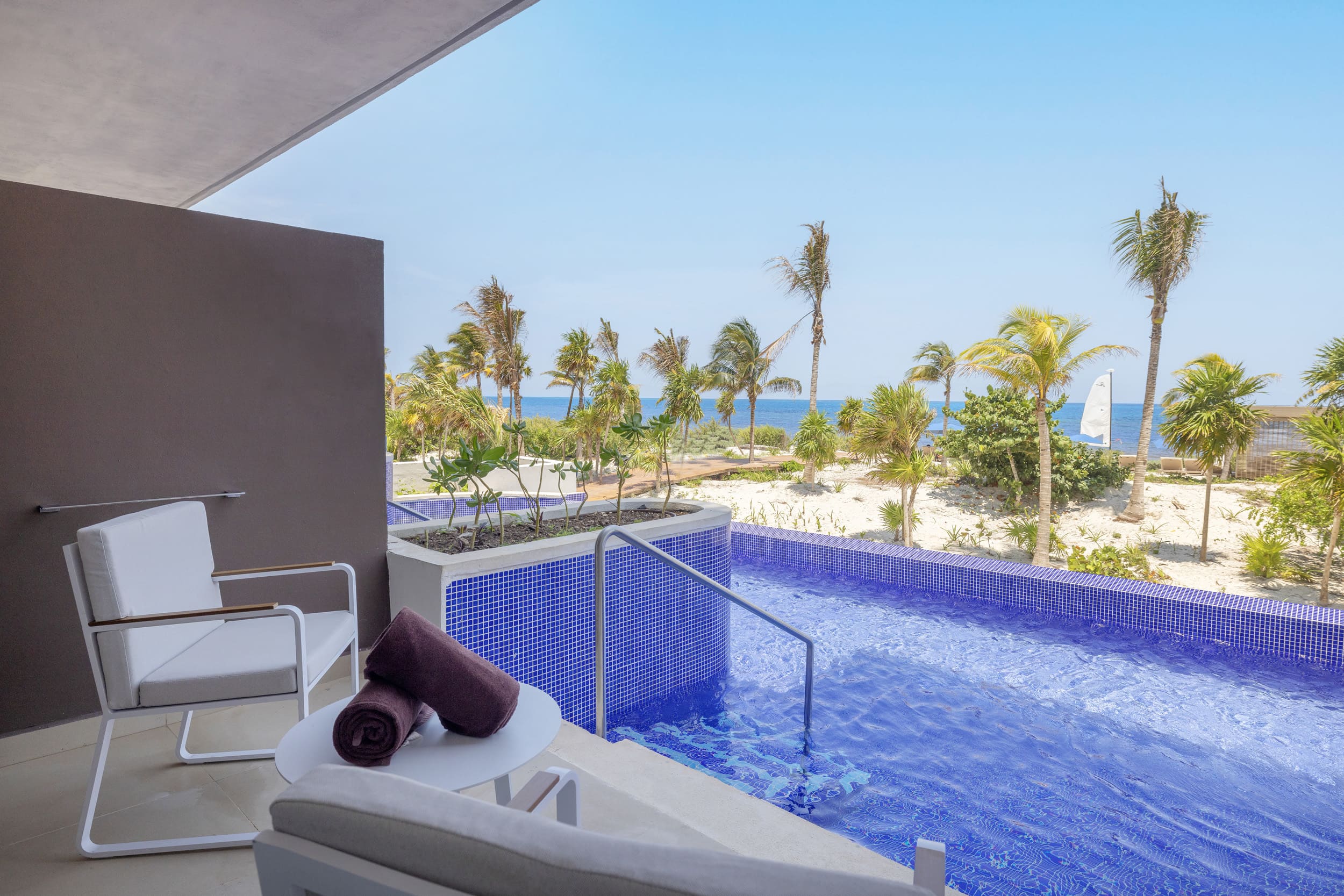 a pool with a view of the ocean and a sailboat