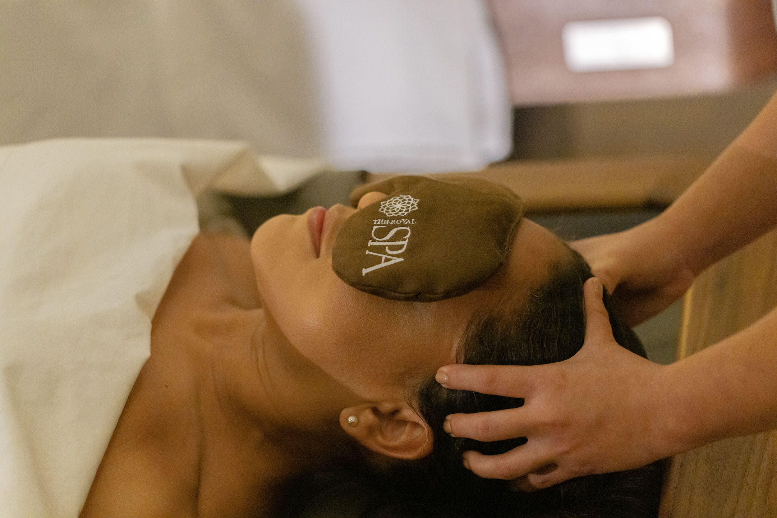 a woman lying down with a brown eye patch on her face