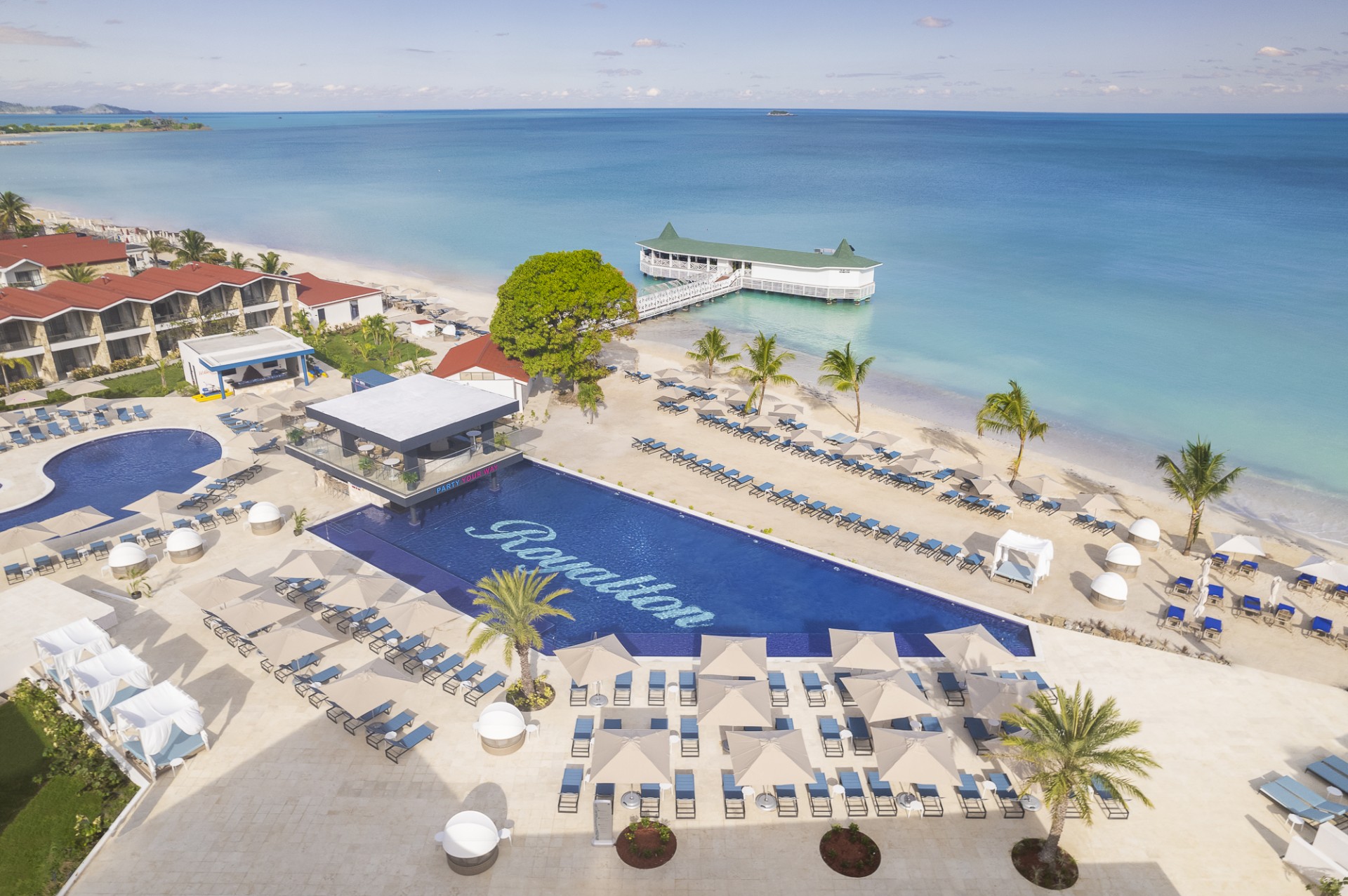 a swimming pool and a beach with a dock