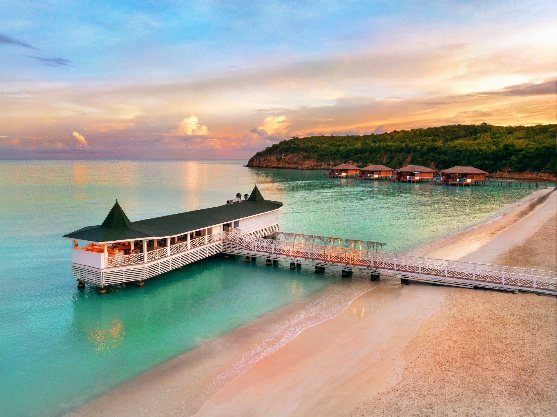 a dock on a beach with houses and a building
