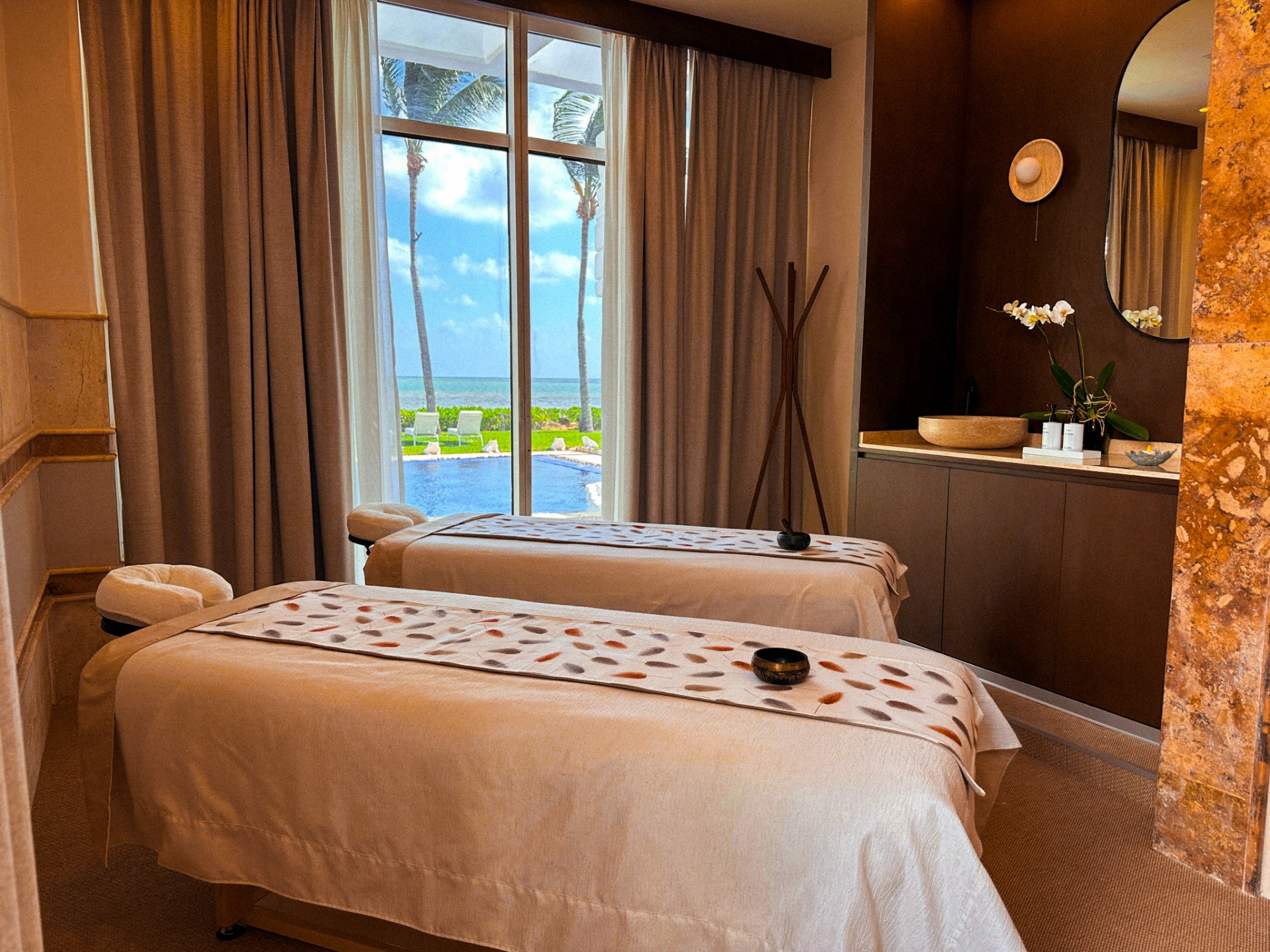 a massage beds in a room with a view of the ocean