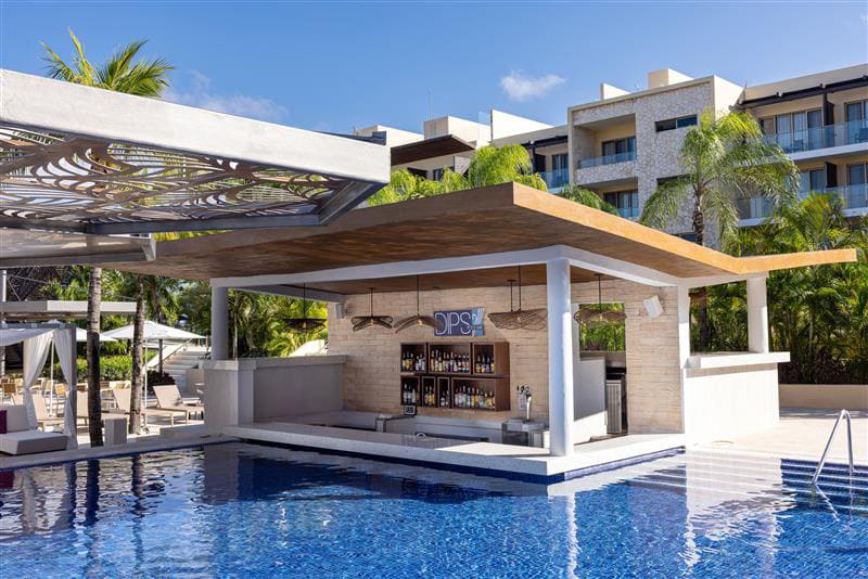 a pool with a bar and a bar with a bar and a building in the background