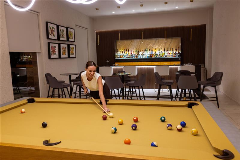 a woman playing pool in a room