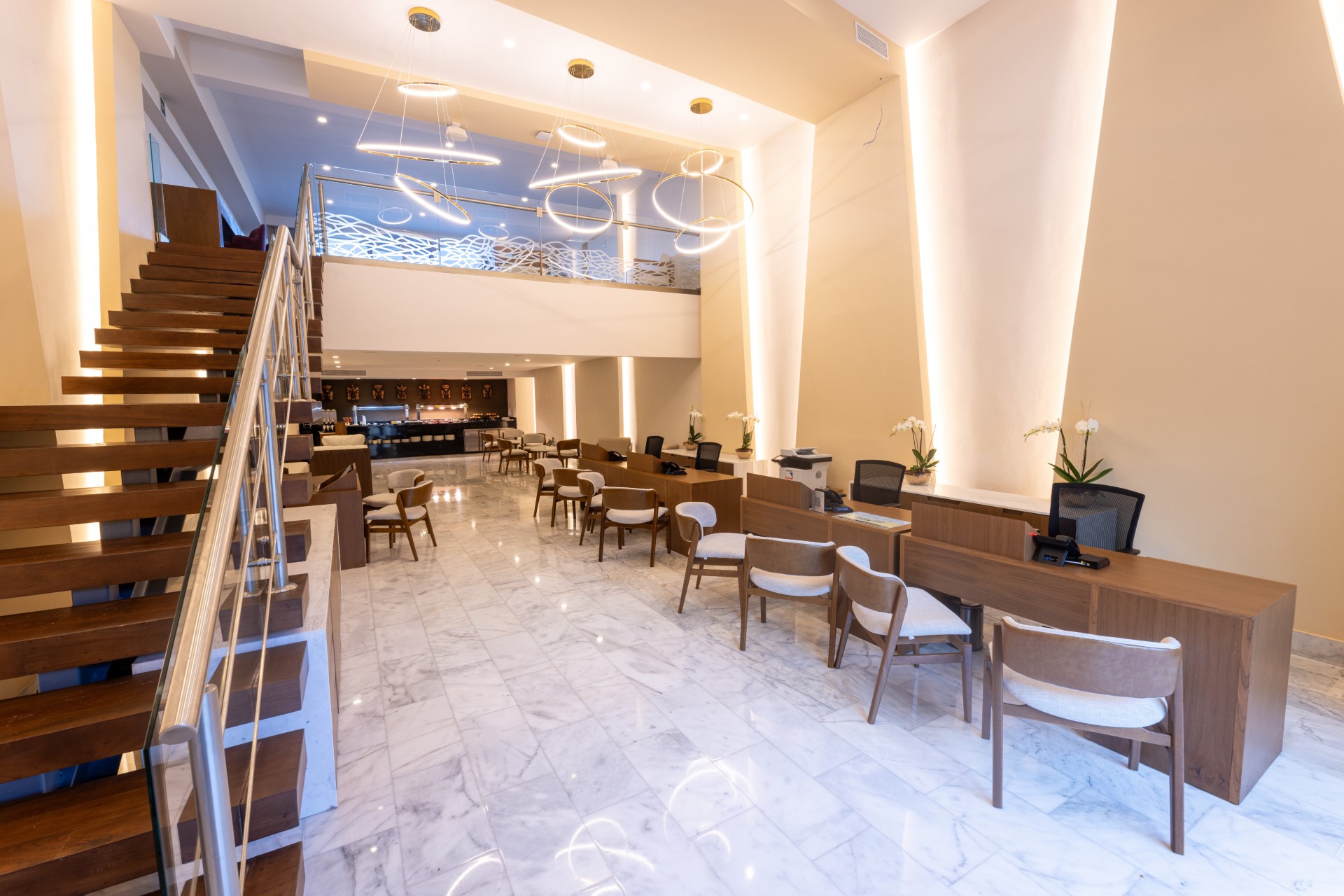 a room with a staircase and tables and chairs